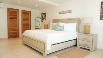 A bedroom with a bed, bedside tables, a mirror, and a wall-mounted sign.