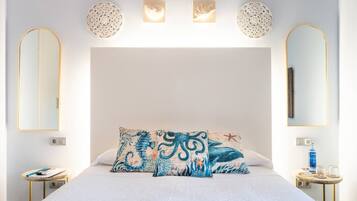 Una camera da letto con un letto grande, due comodini, uno specchio fissato alla parete e applique decorative.