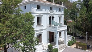 Un bâtiment blanc à deux étages, doté d’un balcon et d’une terrasse couverte.