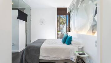 Un dormitorio moderno con una cama, un televisor y un cuadro abstracto grande en la pared.