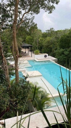 Relax by the serene pool surrounded by lush greenery and tranquil surroundings.