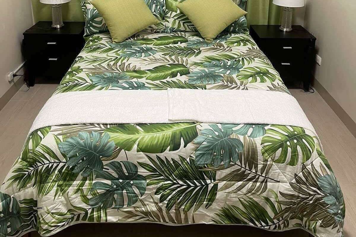 A bedroom with a bed, two nightstands, a headboard, and curtains.