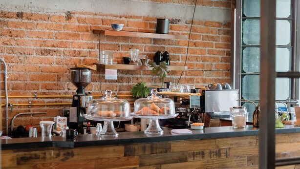 A rustic kitchen with exposed brick walls, pendant lighting, and wooden countertops. - Casa Lomah Napoles WTC (Mexico City)