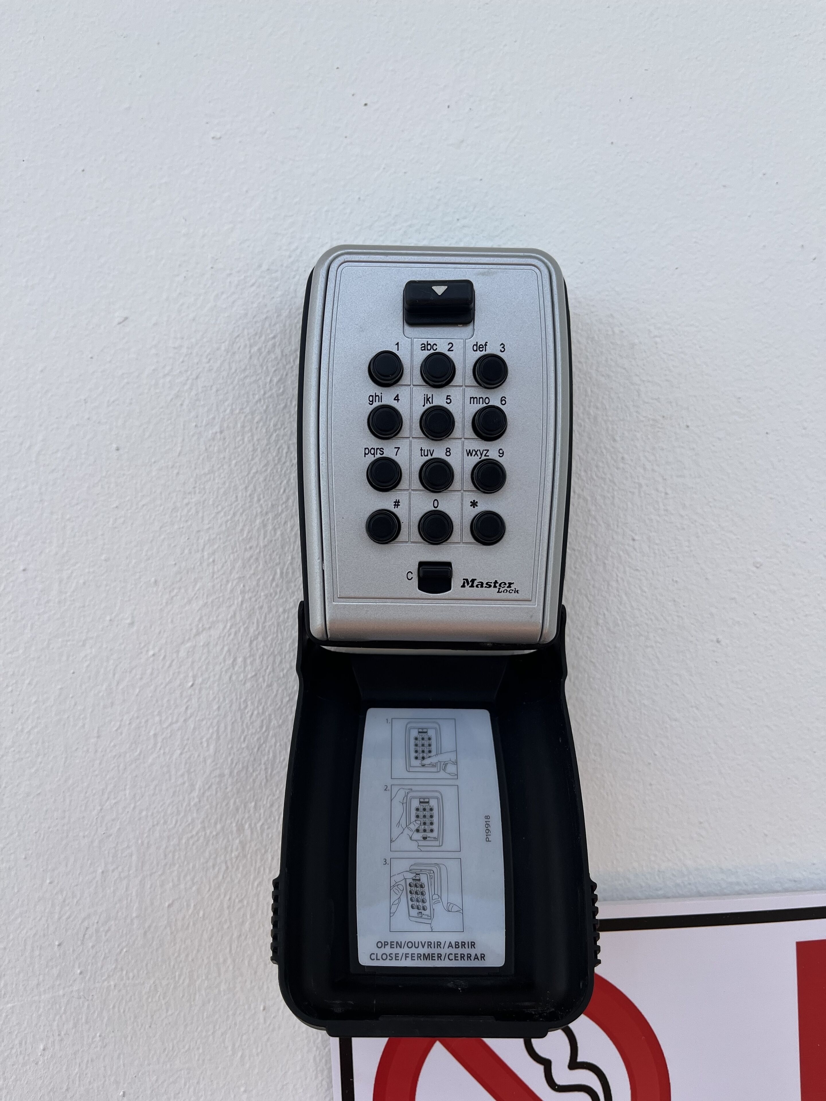 A Master Lock combination lock with a keyhole and a set of instructions in a black case.