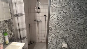 Un baño con ducha, inodoro y lavamanos.