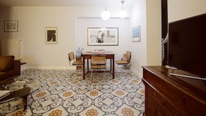 A living room with a dining table, chairs, a sofa, a TV, and patterned floor tiles. - Closed structure, not existing (Potenza)