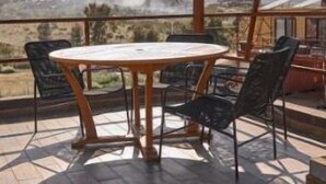 A round wooden table with chairs on a patio with a view of the countryside. - SUEÑA@TierraAmada-in the heart of the valley 1OF7 (Guadalupe, Ensenada)