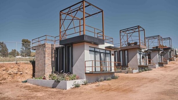 A modern building with multiple structures, each with a metal framework and a flat roof. - SUEÑA@TierraAmada-in the heart of the valley 1OF7 (Guadalupe, Ensenada)