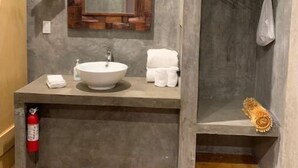 A modern bathroom with a large mirror, a sink, and a towel rack. - SUEÑA@TierraAmada-in the heart of the valley 1OF7 (Guadalupe, Ensenada)