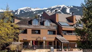 A multi-story building with a sign for 'Gone Bakery' and a mountain backdrop.