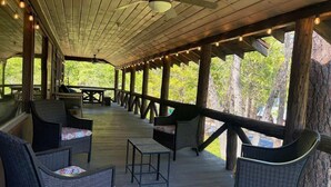 An outdoor covered patio with wicker furniture and string lights.