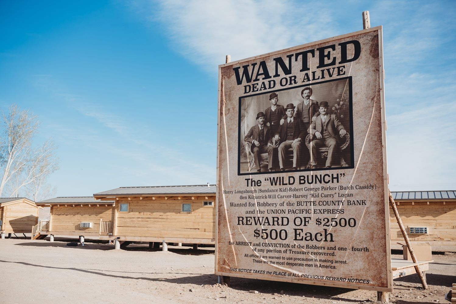 A wanted poster with a reward notice for the 'Wild Bunch' group, including names and a reward of $2500.