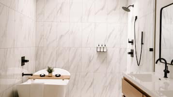 A modern bathroom with a freestanding bathtub, a shower area, and a vanity with a mirror.