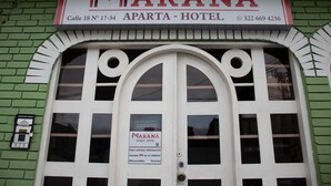A hotel entrance with a sign reading "MARANÁ APTA - HOTEL" and a contact number. - Ayenda Maraná (Manizales)
