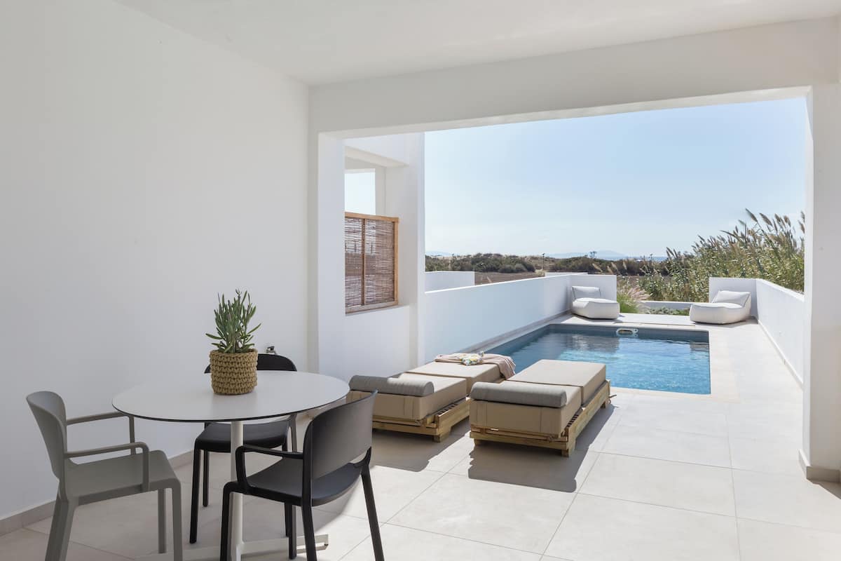 A modern outdoor patio with a pool, seating area, and a dining table.