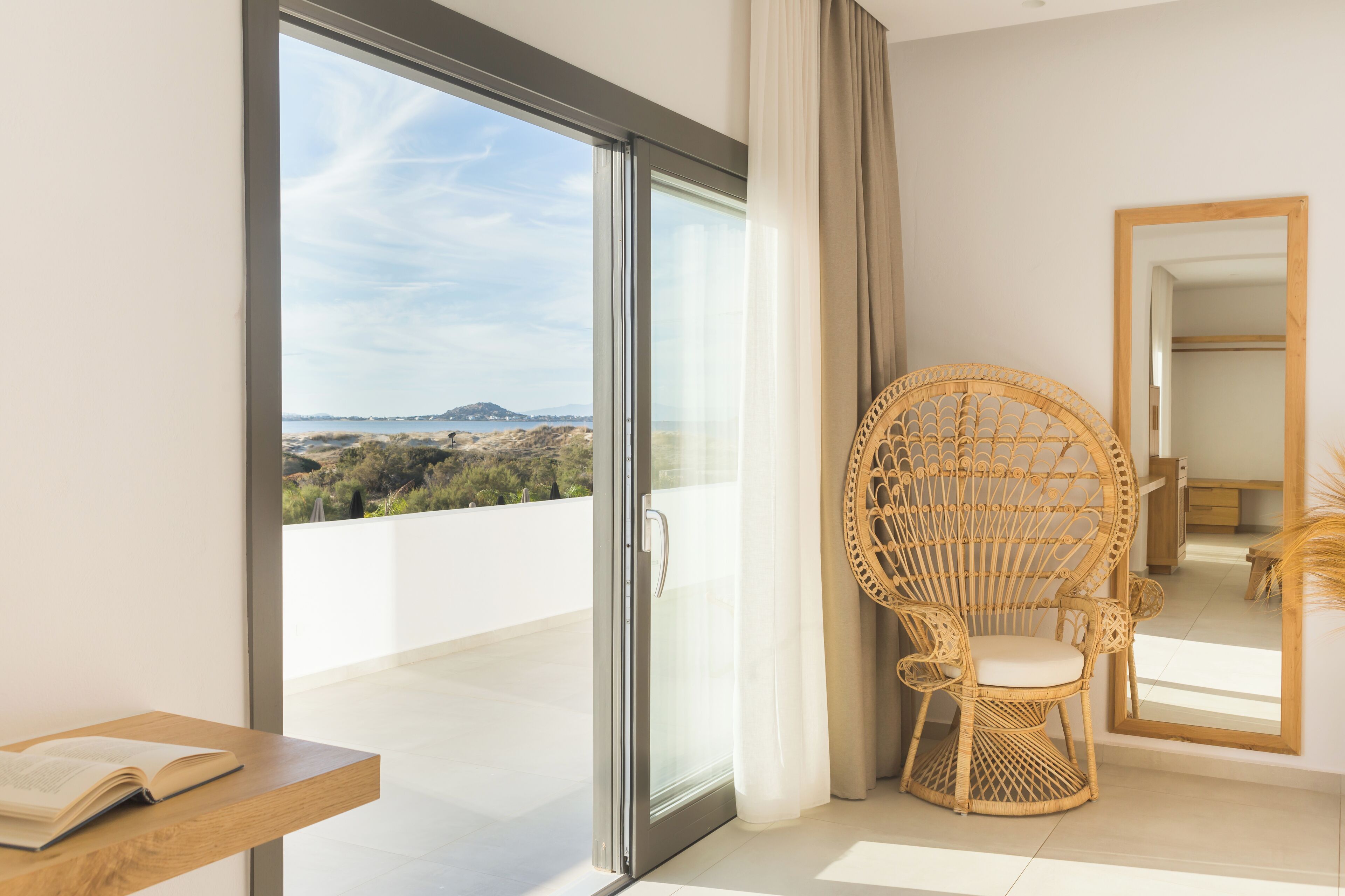 A room with a large sliding glass door leading to a balcony with a scenic view.