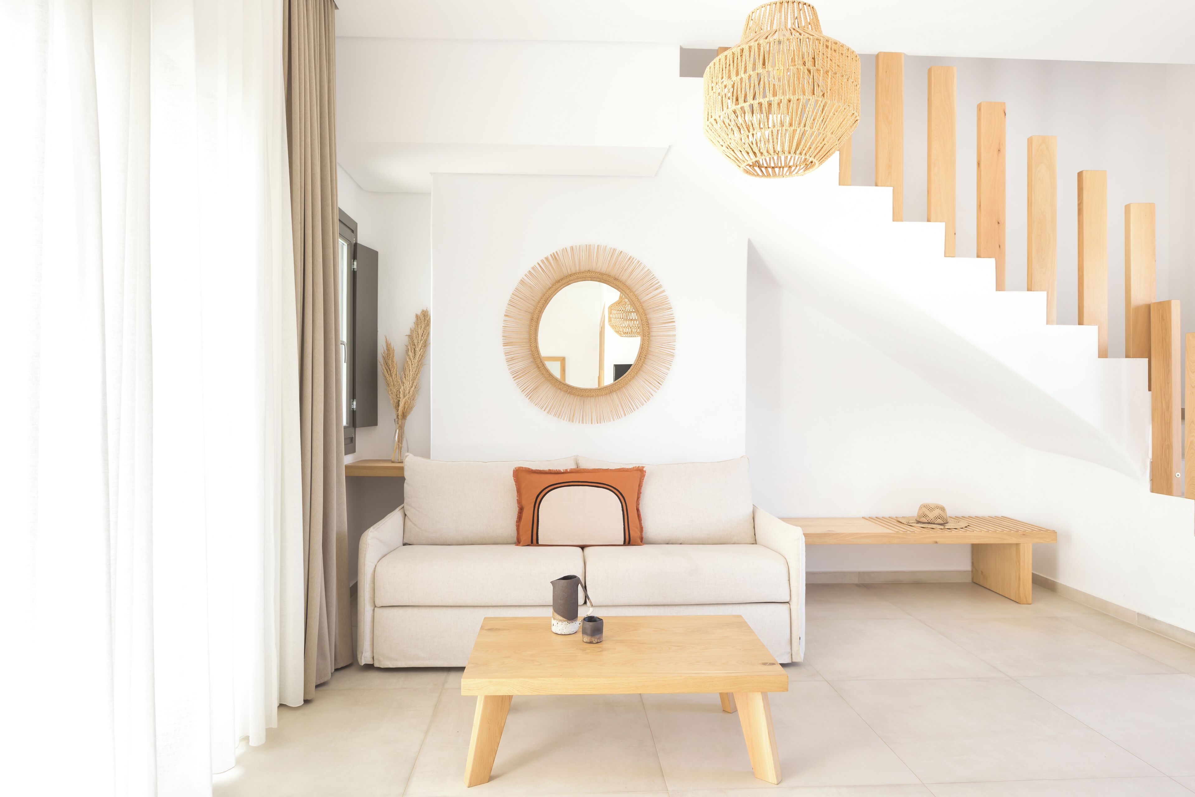 A modern living room with a sofa, coffee table, and a staircase with wooden steps.