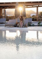 Una piscina al aire libre de temporada, sombrillas, tumbonas