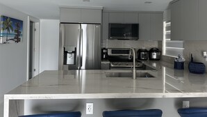 A modern kitchen with a stainless steel refrigerator, a built-in oven, a microwave, and a coffee maker. - Relaxing home in a beautiful location with luxurious accommodations (Key Largo)