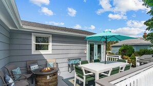 A covered patio with a fire pit, outdoor seating, and a table. - Reserve Fall 2026! Beach House in the Pier W/ POOL, short walk to the beach! (Narragansett)