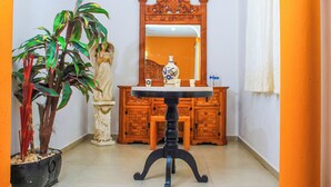Une pièce comprenant une table à manger, un miroir et une plante en pot.