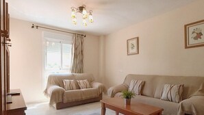 A living room with two sofas, a coffee table, and a chandelier. - TERRASOL AZUCARERA 3 DORMITORIOS (Torre del Mar)