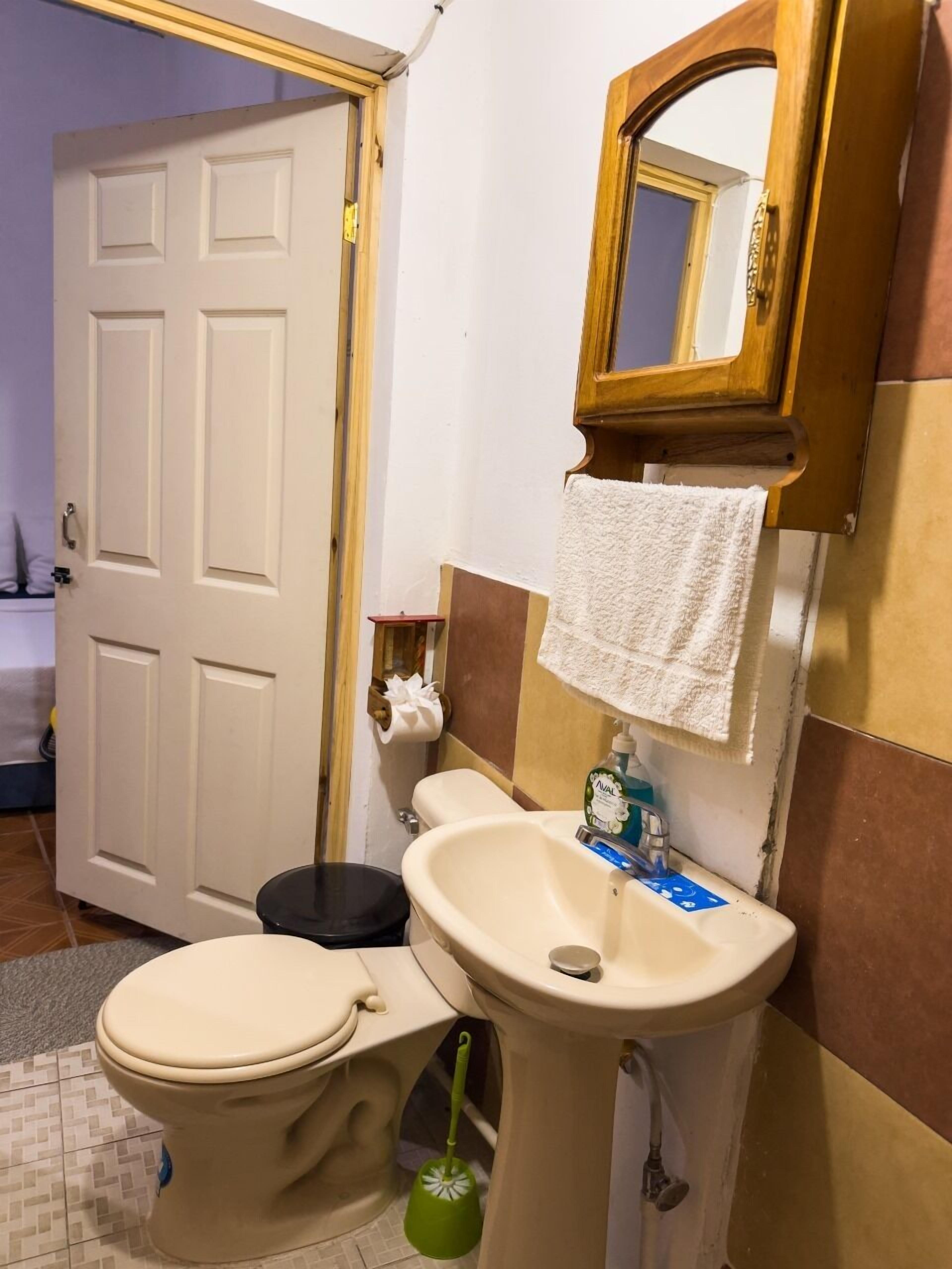 Ein Badezimmer mit Toilette, Waschbecken und Spiegel.