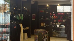 Ένα κατάστημα με μια επιγραφή νέον που γράφει «ΤΟΠΙΚΟ» και στο οποίο εκτίθενται διάφορα είδη αθλητικού εξοπλισμού και αθλητικά ρούχα.
