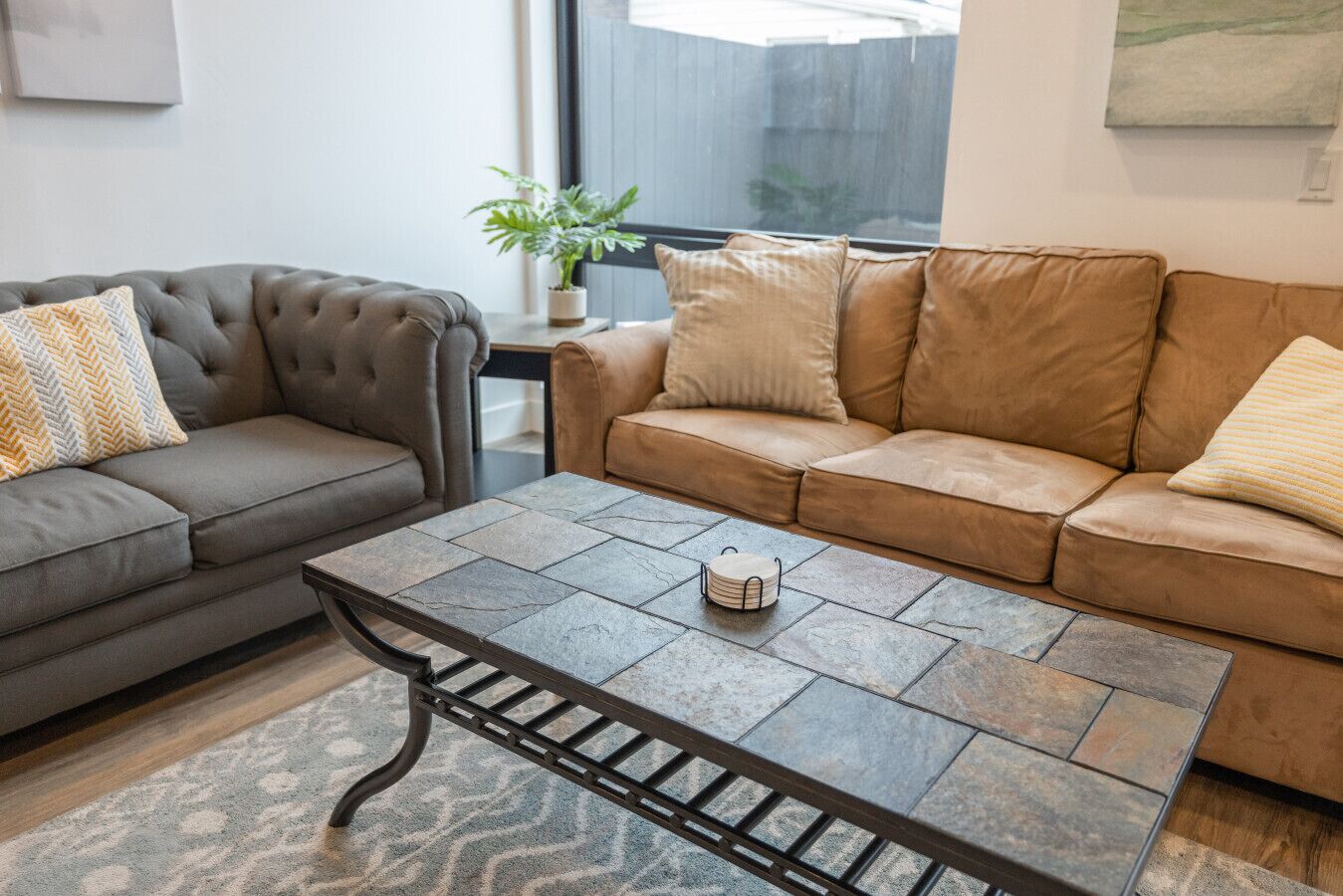 Un salon avec deux canapés, une table basse et une plante en pot.