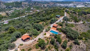 Vista aérea de una propiedad rural con dos cabañas, una piscina y vegetación circundante.