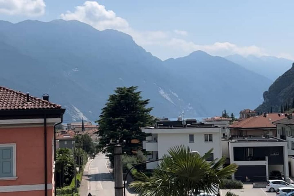 Une rue bordée d’immeubles, une montagne en arrière-plan et un ciel dégagé.
