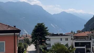 Une rue bordée d’immeubles, une montagne en arrière-plan et un ciel dégagé.