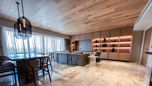Una cocina moderna con una isla central, un comedor con sillas y una encimera.