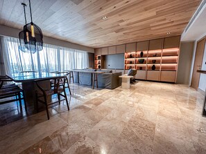 A modern kitchen with a central island, a dining area with chairs, and a kitchen counter.
