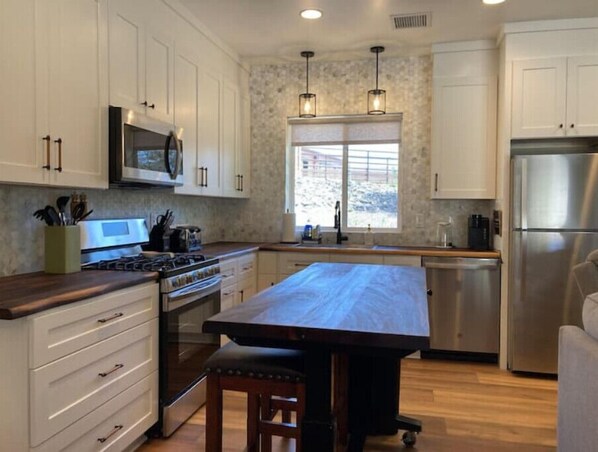 Enjoy cooking in this well-equipped kitchen with a large island, microwave, and pendant lights.