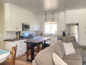Enjoy cooking in the well-equipped kitchen with a microwave, stove, and refrigerator, and dine at the wooden dining table with comfortable seating for two.