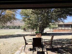 Relax on the patio surrounded by lush greenery and enjoy the serene atmosphere.
