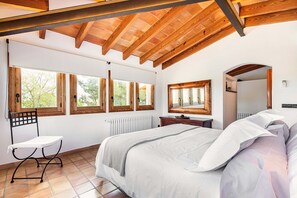 A bedroom with a large bed, wooden ceiling beams, and multiple windows. - VILLA CAL MOLINER  with private pool. (Pollensa)