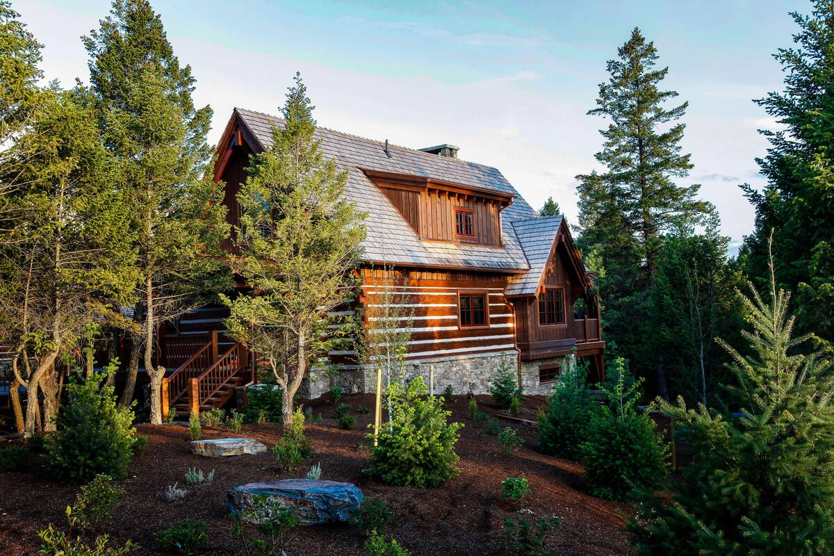 A log cabin with a stone foundation, wooden exterior, and a balcony.