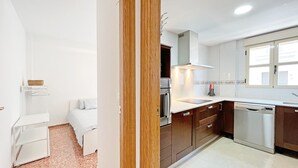 A modern kitchen with white cabinets, a stainless steel dishwasher, and a countertop with a sink.
