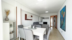 Ein modernes Wohnzimmer mit Essbereich, Fernseher und einem Gemälde an der Wand.