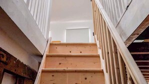 A staircase with white railings and a skylight.