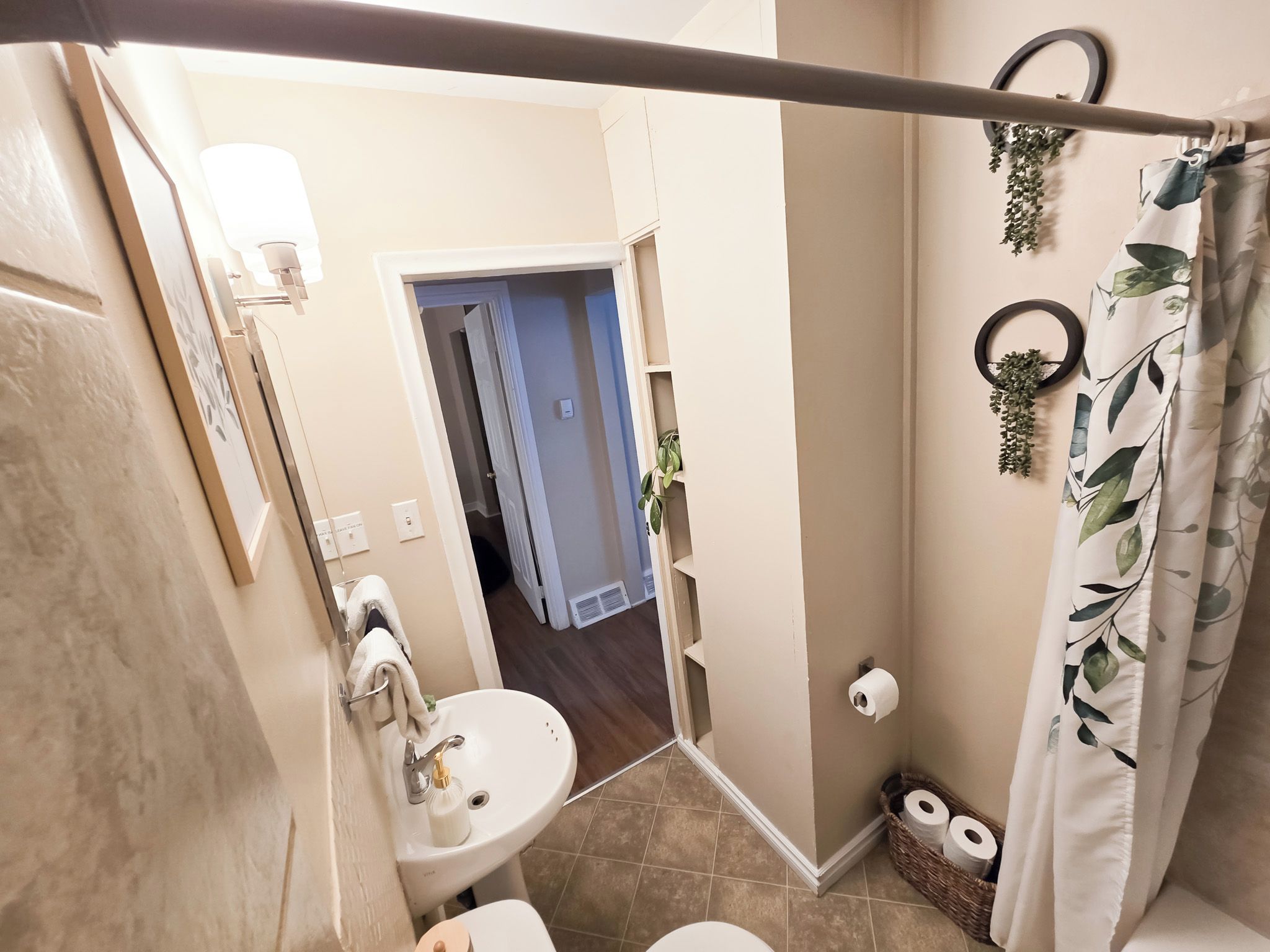 Un baño con inodoro, lavamanos y cortina de ducha.