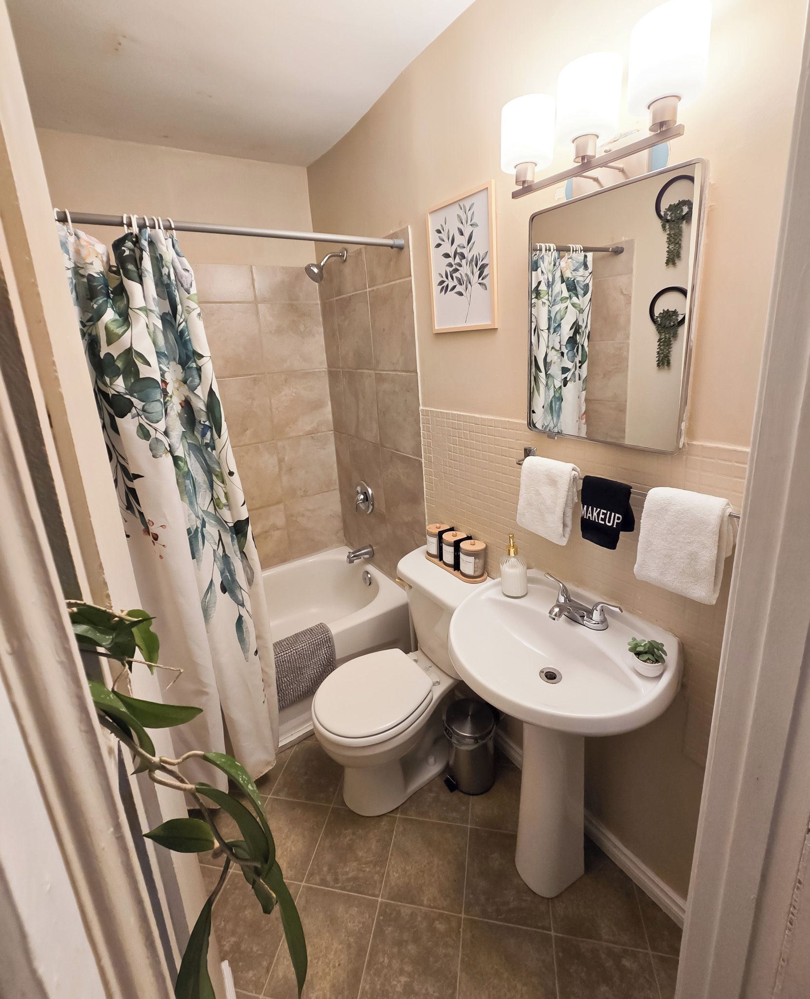 Un baño con ducha, inodoro, lavabo y un espejo con iluminación.