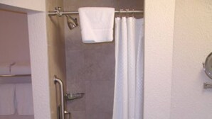 Et badeværelse med bruser, toilet og håndvask.