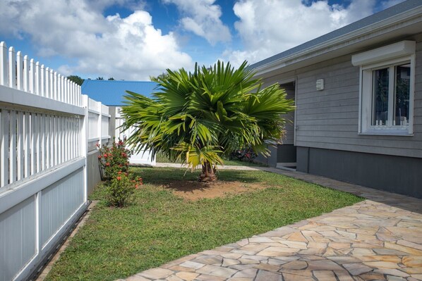 A residential property with a well-maintained lawn, a palm tree, and a stone pathway leading to the house. - Kaju Pool House, close to the beach (Sainte-Luce)