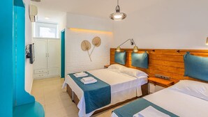 A hotel room with two beds, a wooden headboard, a white wall with a textured design, a window, and a door. - Avlu Butik Otel Palamutbükü (Datça)