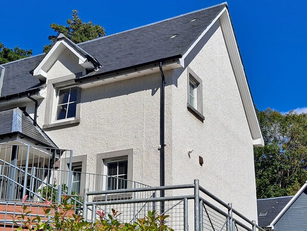 A two-story building with a grey roof and white exterior walls. There are two windows on the upper floor and one on the lower floor. - Taigh Geal (Killin)
