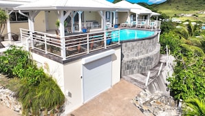 A resort with a pool, white buildings, and a view of the hills. - Villa Eskarcel, très spacieuse, vue mer sur Orient Bay, 4 chambres (Mont Vernon)