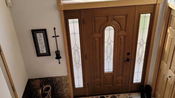 A wooden door with frosted glass panels, a small rug, and a pair of shoes on the floor. - Location: By Target Center, US Bank Stadium, Target Field & Blaine Sports Ctr! (Blaine)
